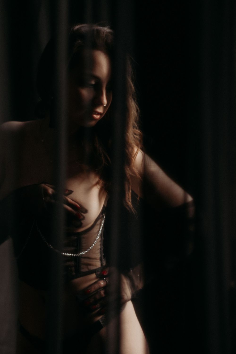 A dramatic portrait series in dark moody lighting shows a silhouetted figure wearing jewelry against a black background.