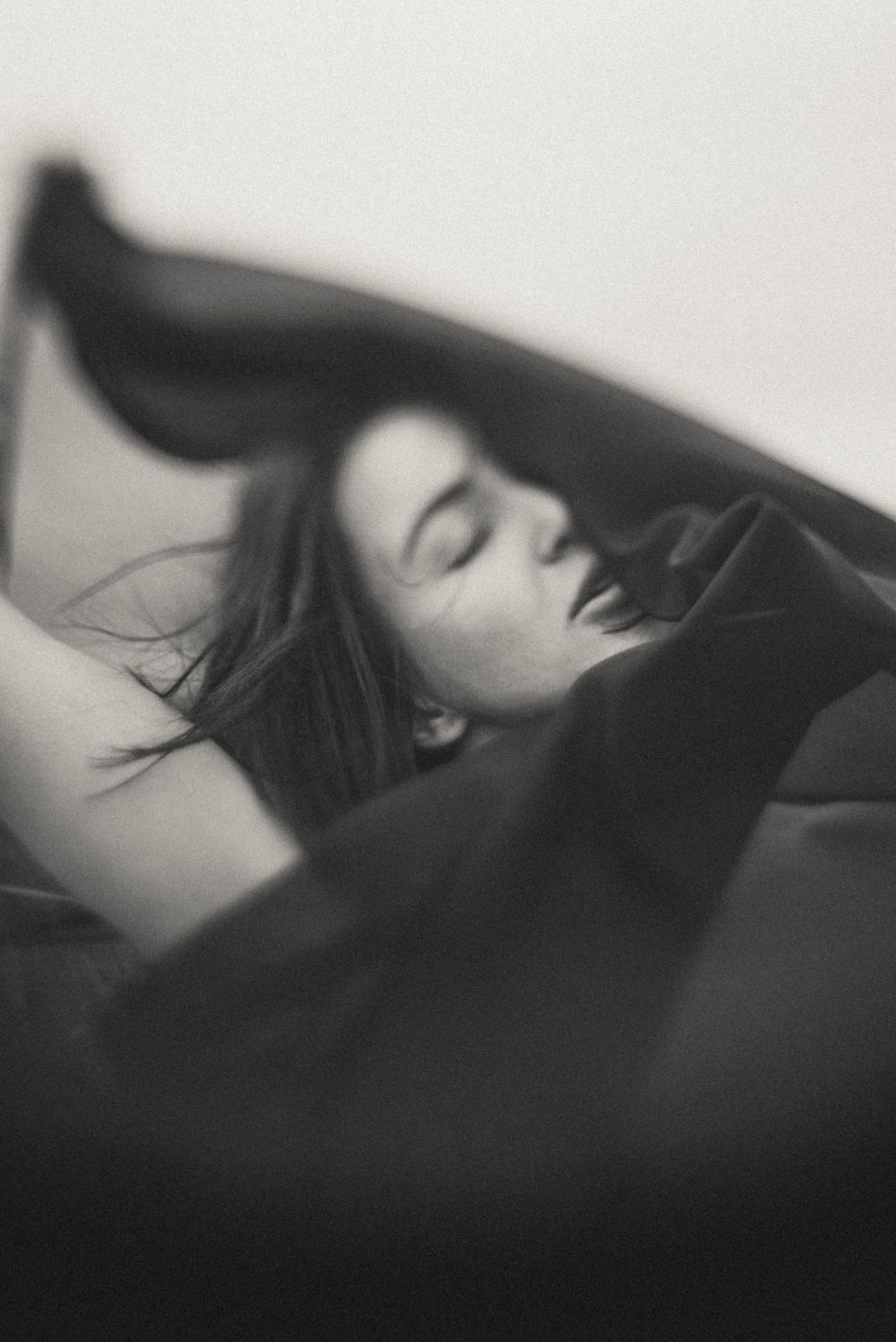 A series of black and white artistic photographs showing a reclining figure in profile with flowing dark hair.