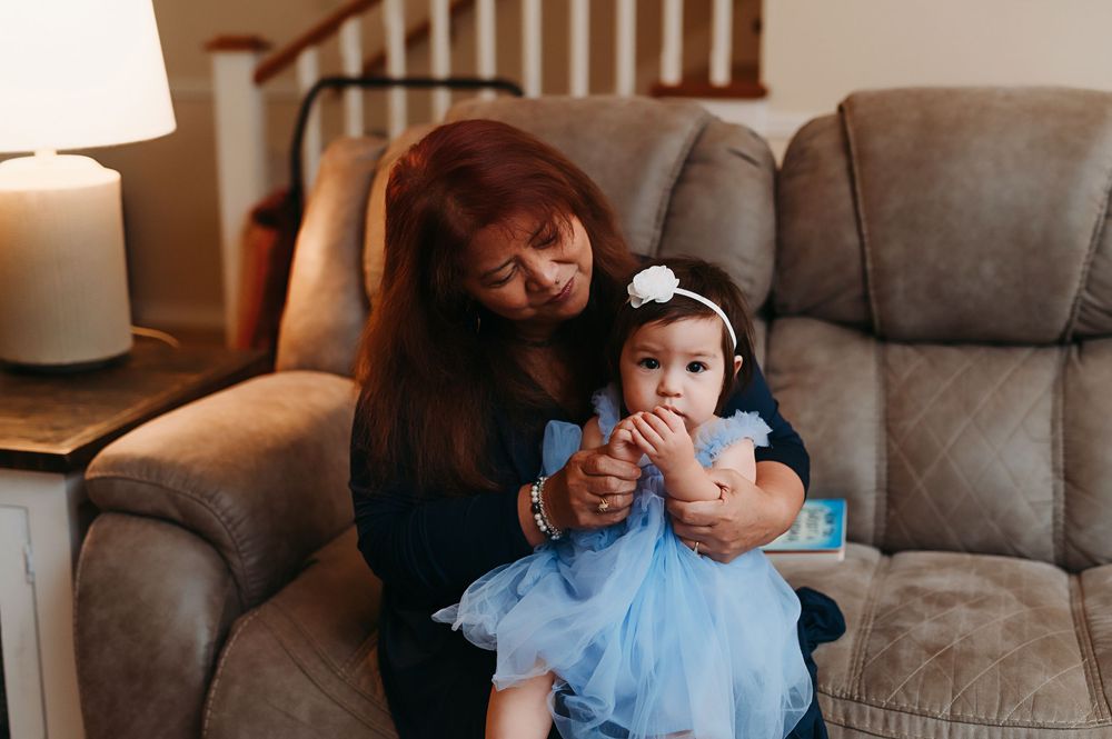 Grandma sitting with her granddaughter on the couch snuggling.