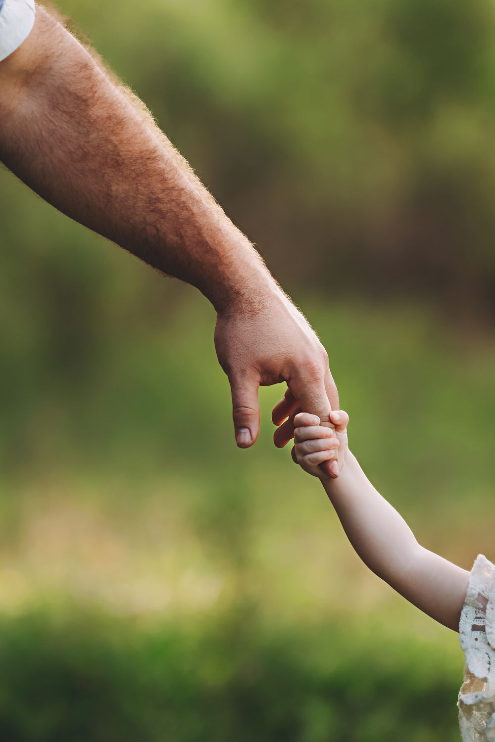Father holding his baby girls finger.