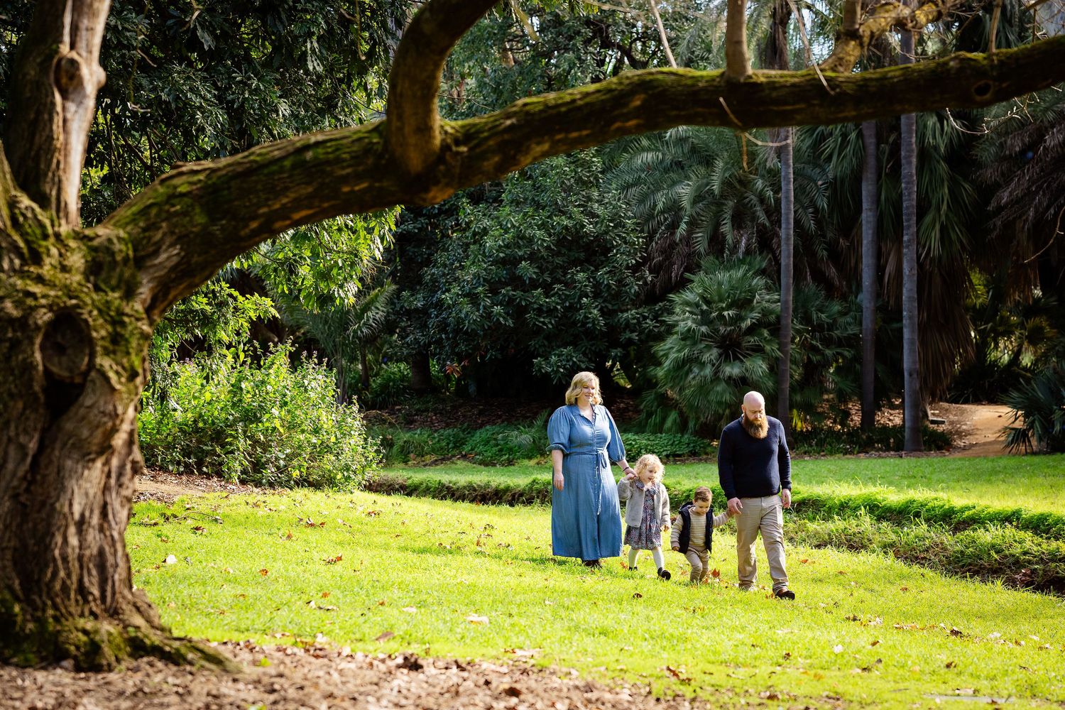 Playful outdoor family photoshoot showing joyful interactions between family members.