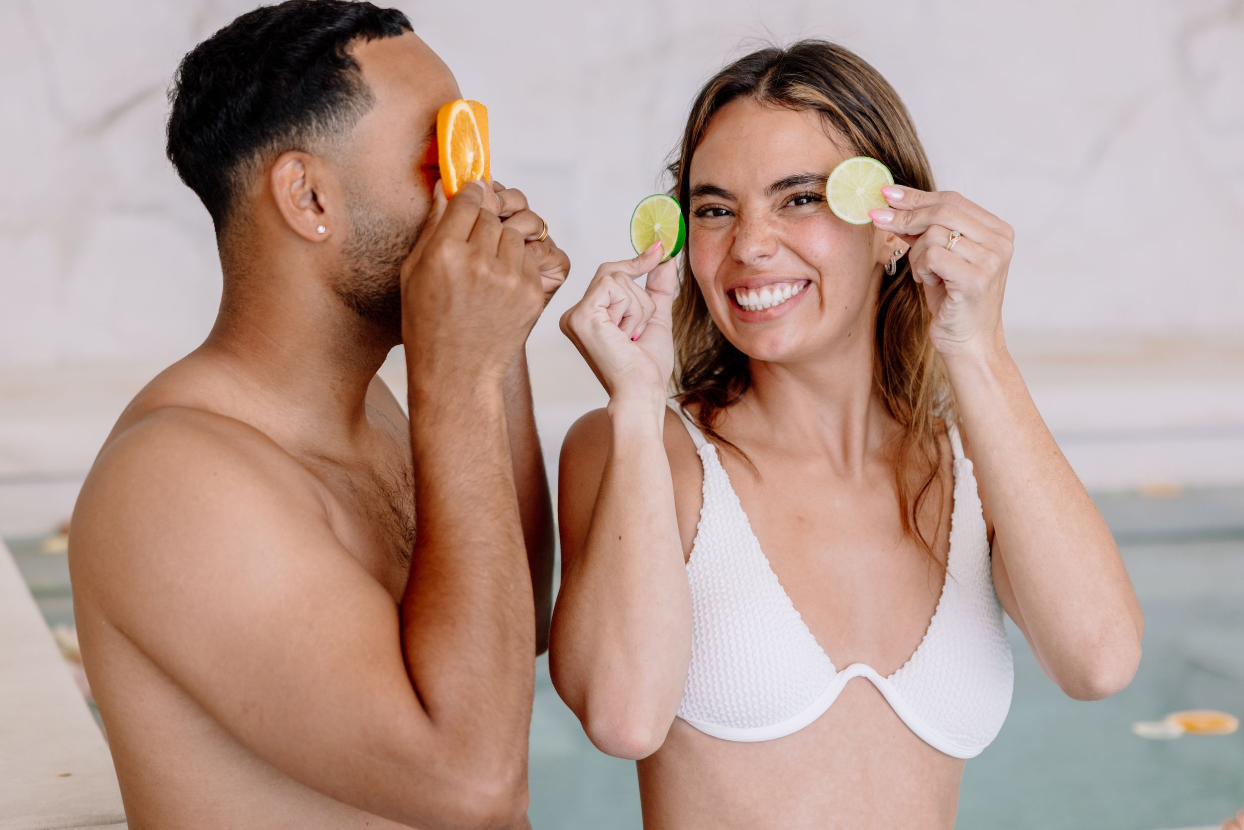 Couple sharing intimate moments in a bright white indoor setting.