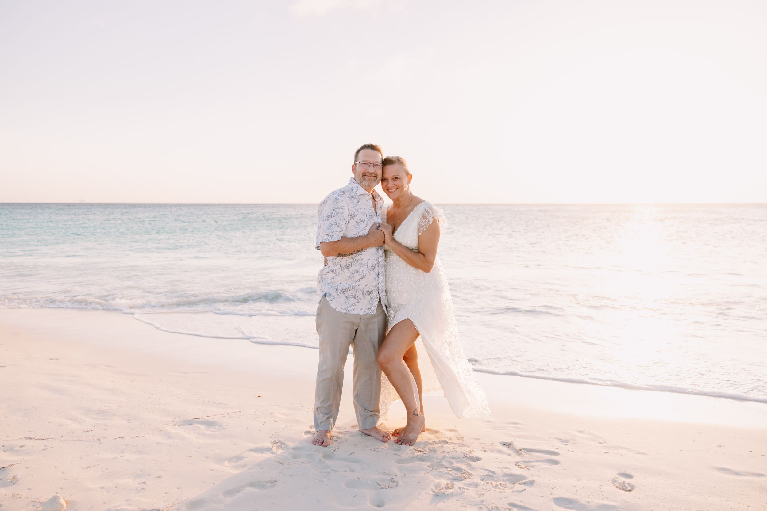A romantic beach photoshoot with palm trees and soft sunset lighting on a tropical shoreline.