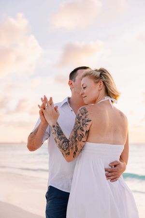 Intimate beach portrait session at sunset with gentle ocean waves in the background.