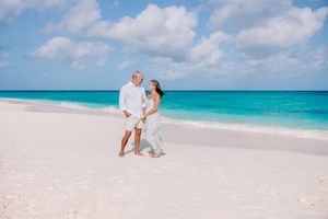Beautiful beach engagement photos with turquoise ocean and white sand backdrop.