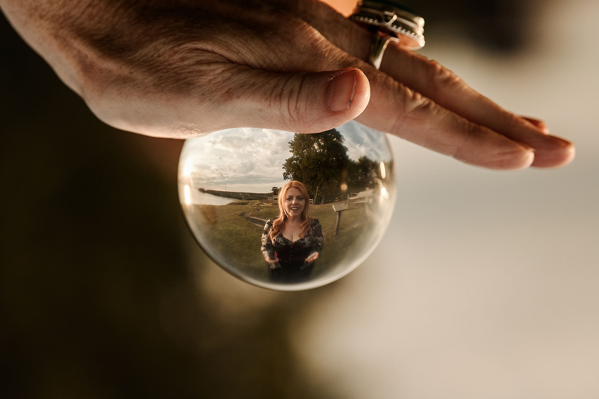 A sequence of photos showing a hand manipulating a glass sphere containing a small figurine inside.