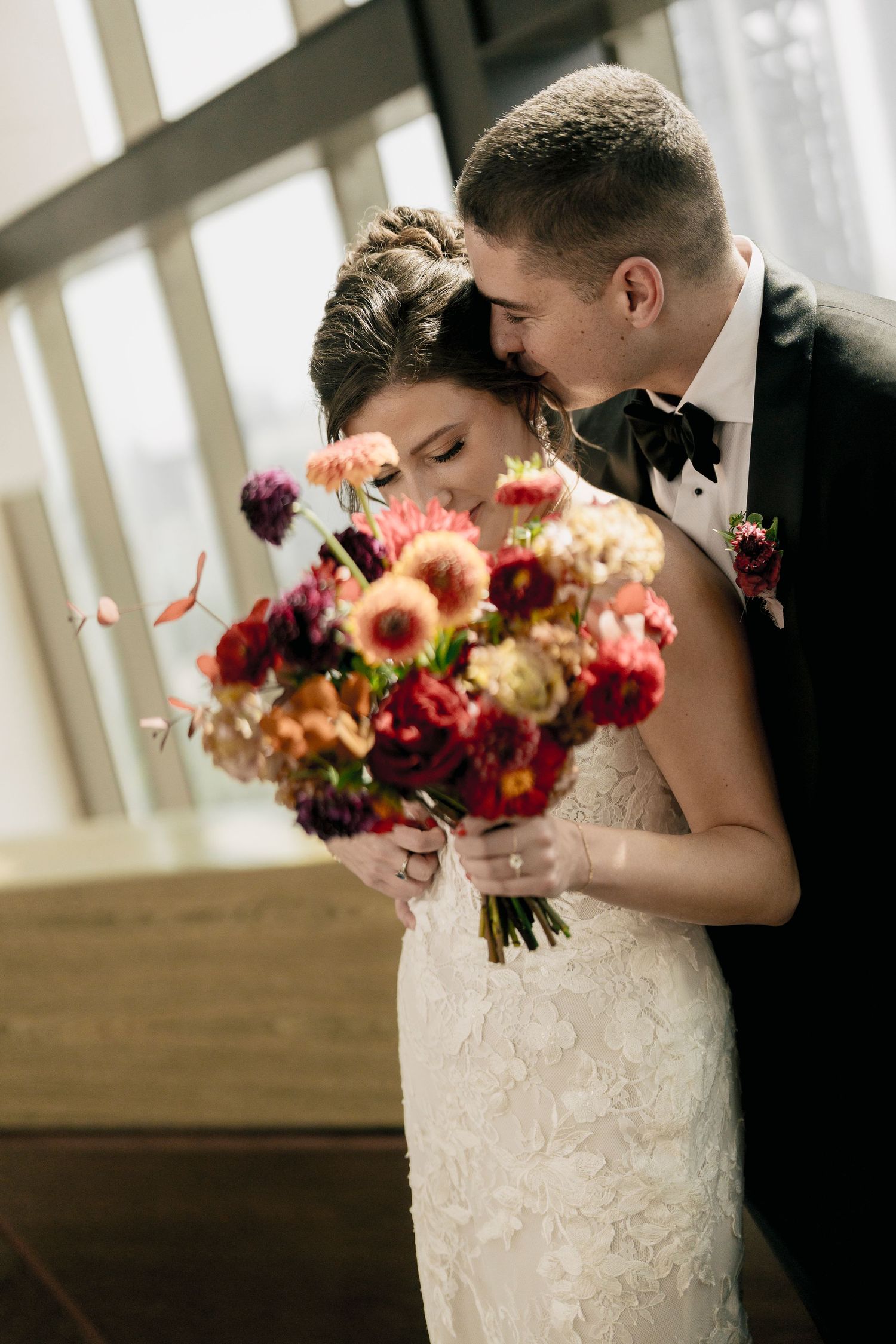 A romantic wedding moment captured in a sequence of four photos showing a couple embracing with a vibrant fall bouquet.