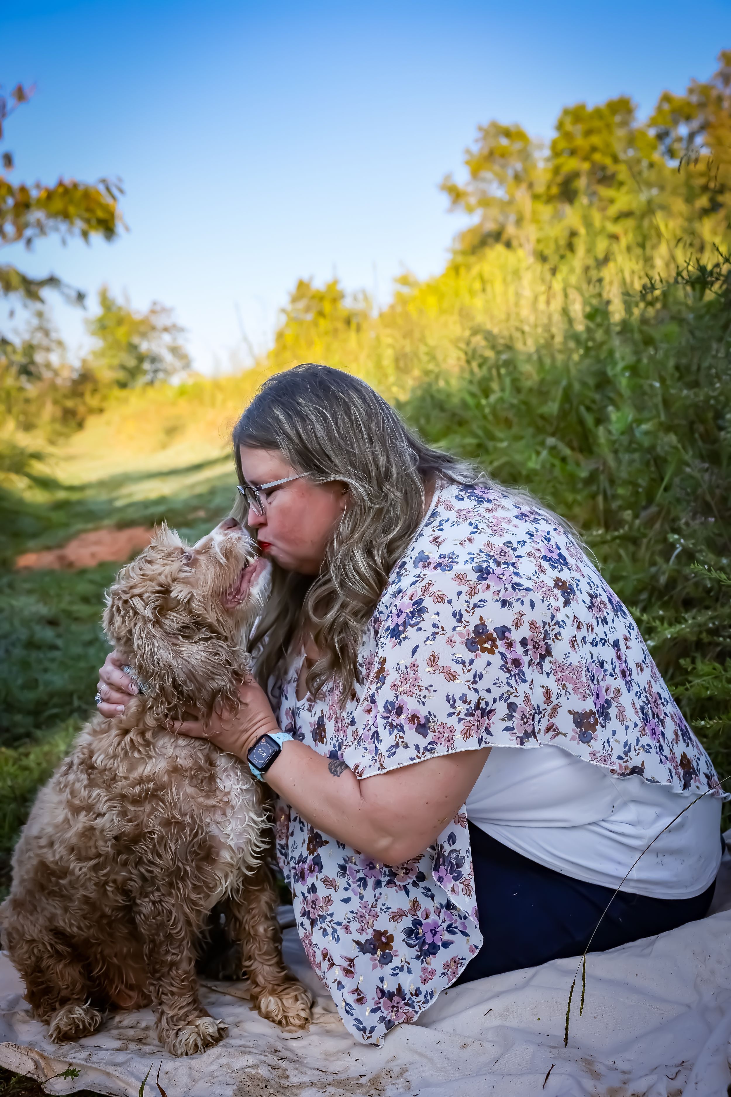 A curly-haired brown dog receives affectionate kisses in a series of outdoor photos with natural lighting.