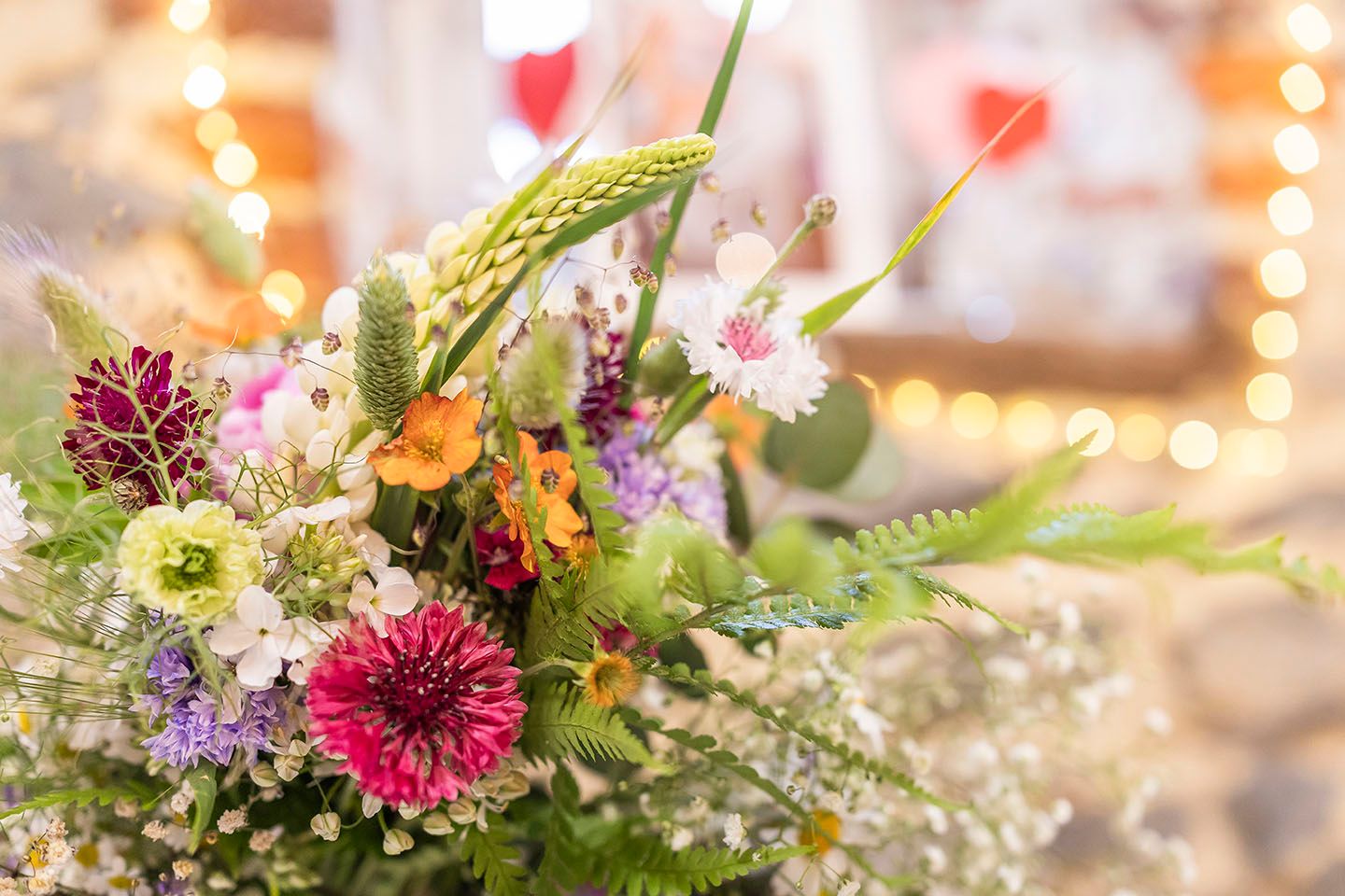 Colorful wildflower arrangement with fairy lights in soft focus.