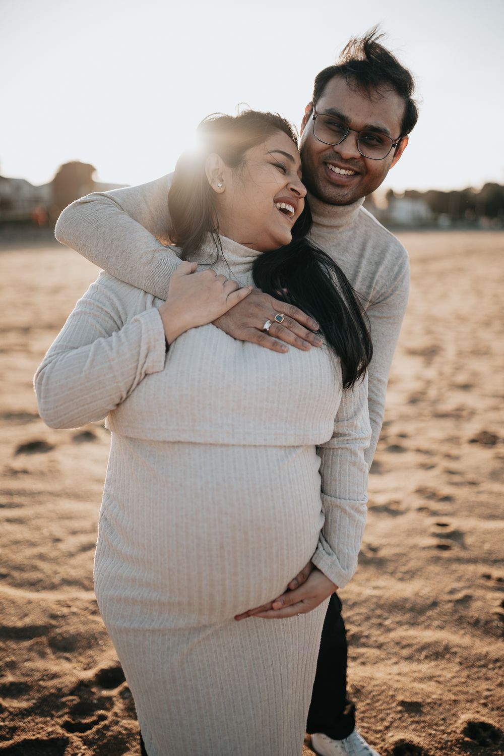 Loving couple embracing while holding her pregnant belly taken by a Melbourne maternity photographer.