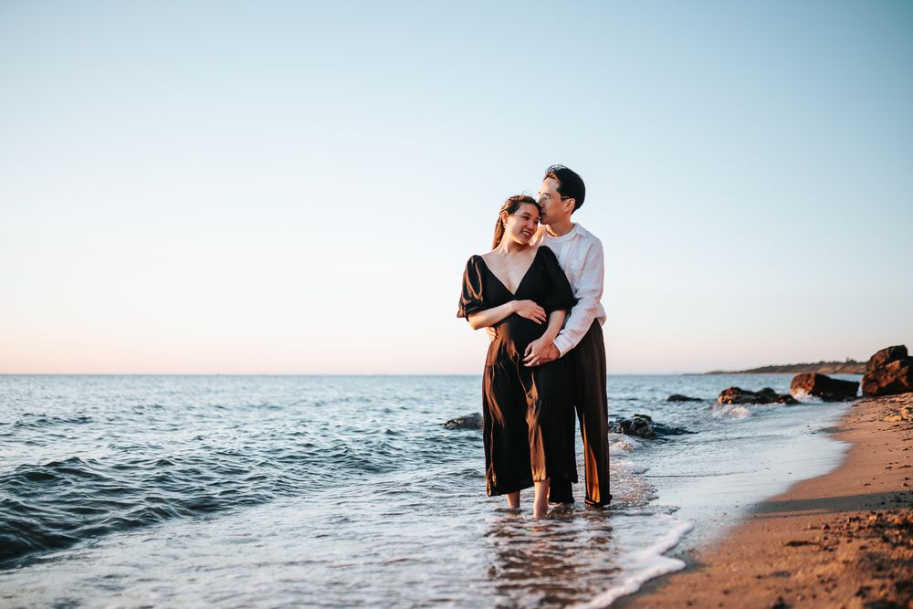 A pregnant couple portrait taken on the beach during a Melbourne sunset maternity photo session