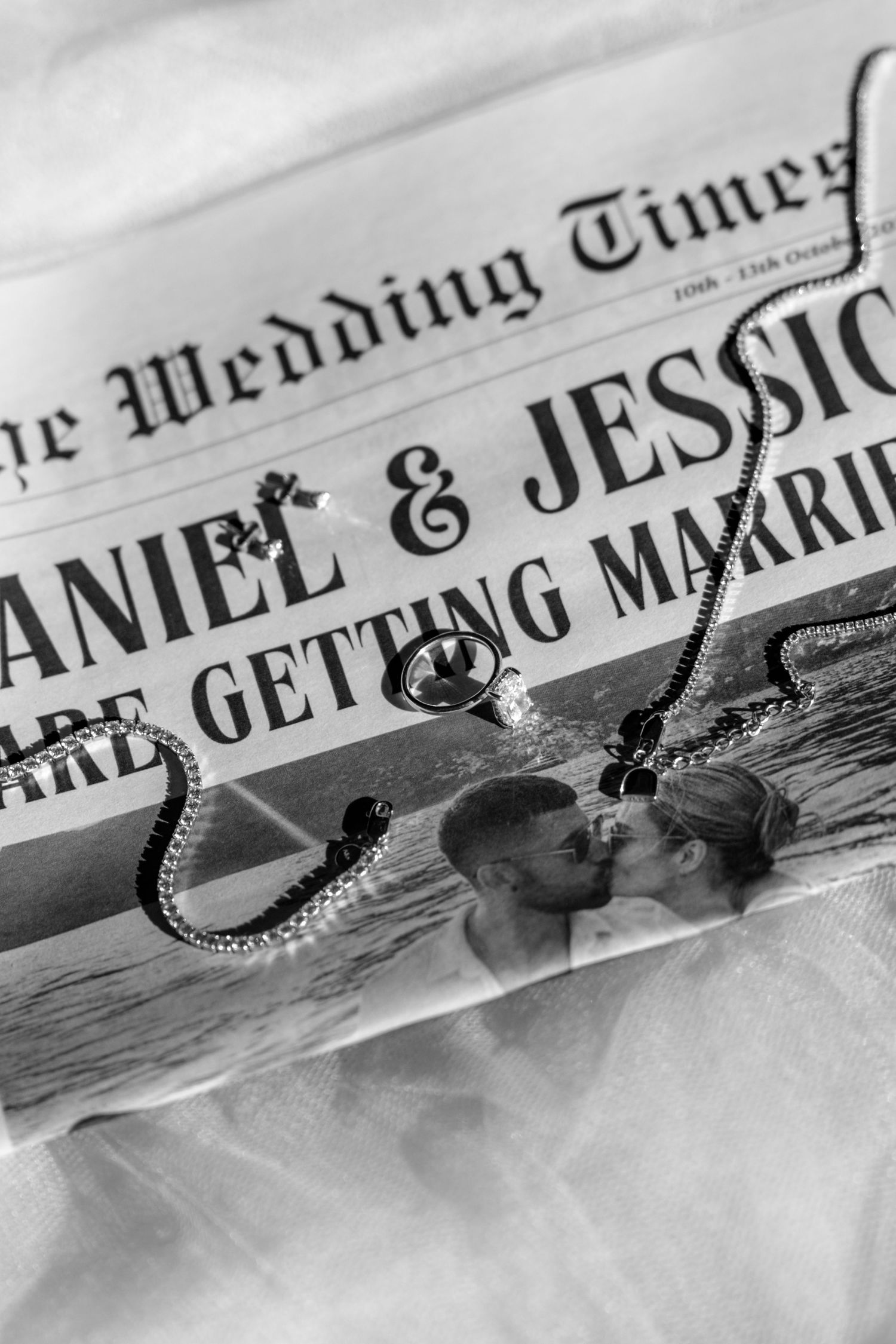 Wedding announcement in newspaper style with engagement ring detail.