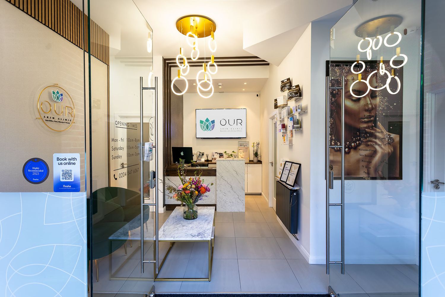 Modern salon interior with hanging pendant lights, sleek furniture, and minimalist decor features a clean white and grey aesthetic.