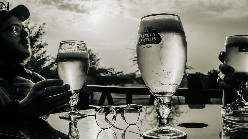 Beer glasses on outdoor table captured in black and white photography.