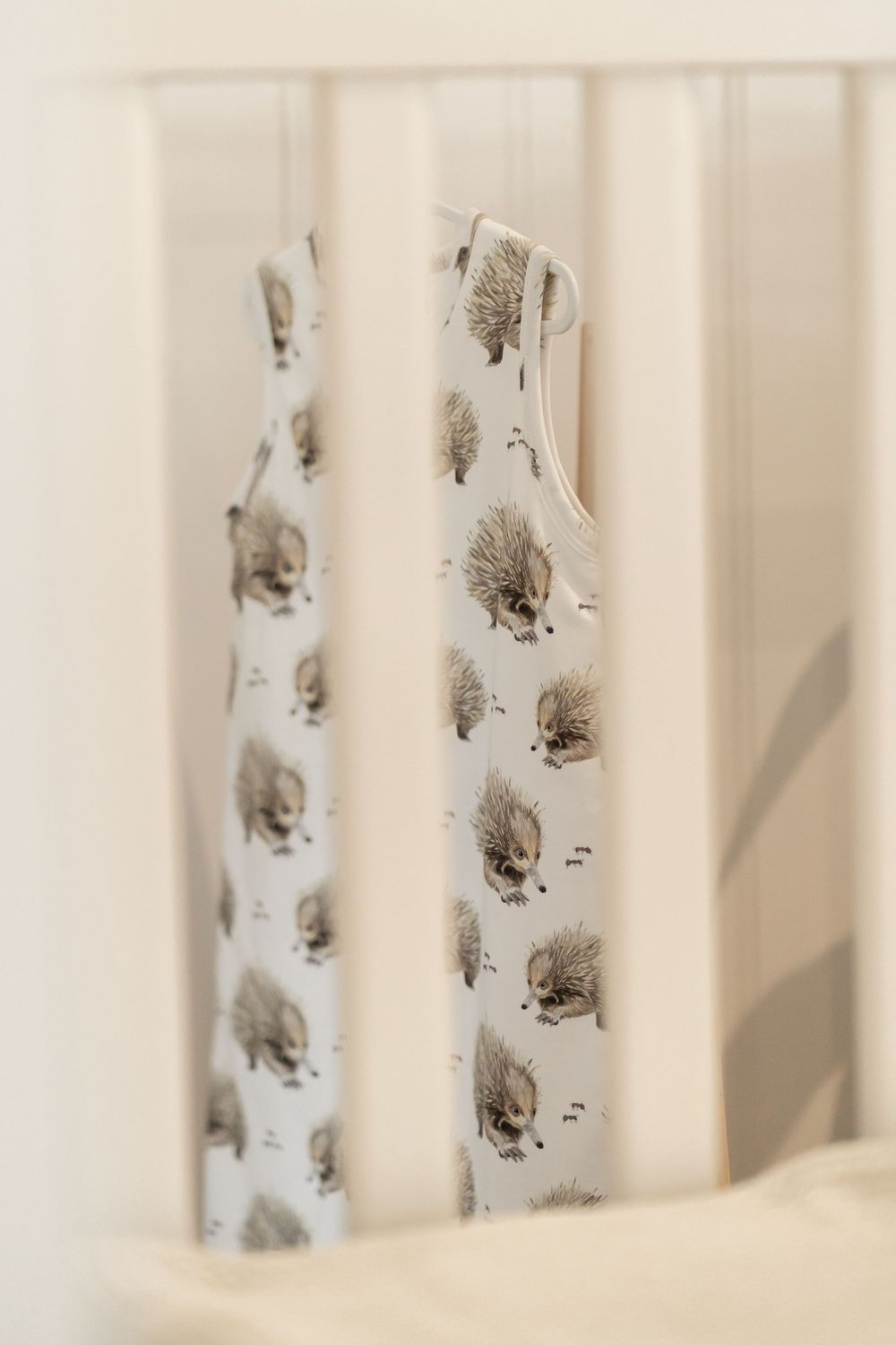 White crib bars with delicate grey bird pattern decals creating a soft nursery aesthetic.