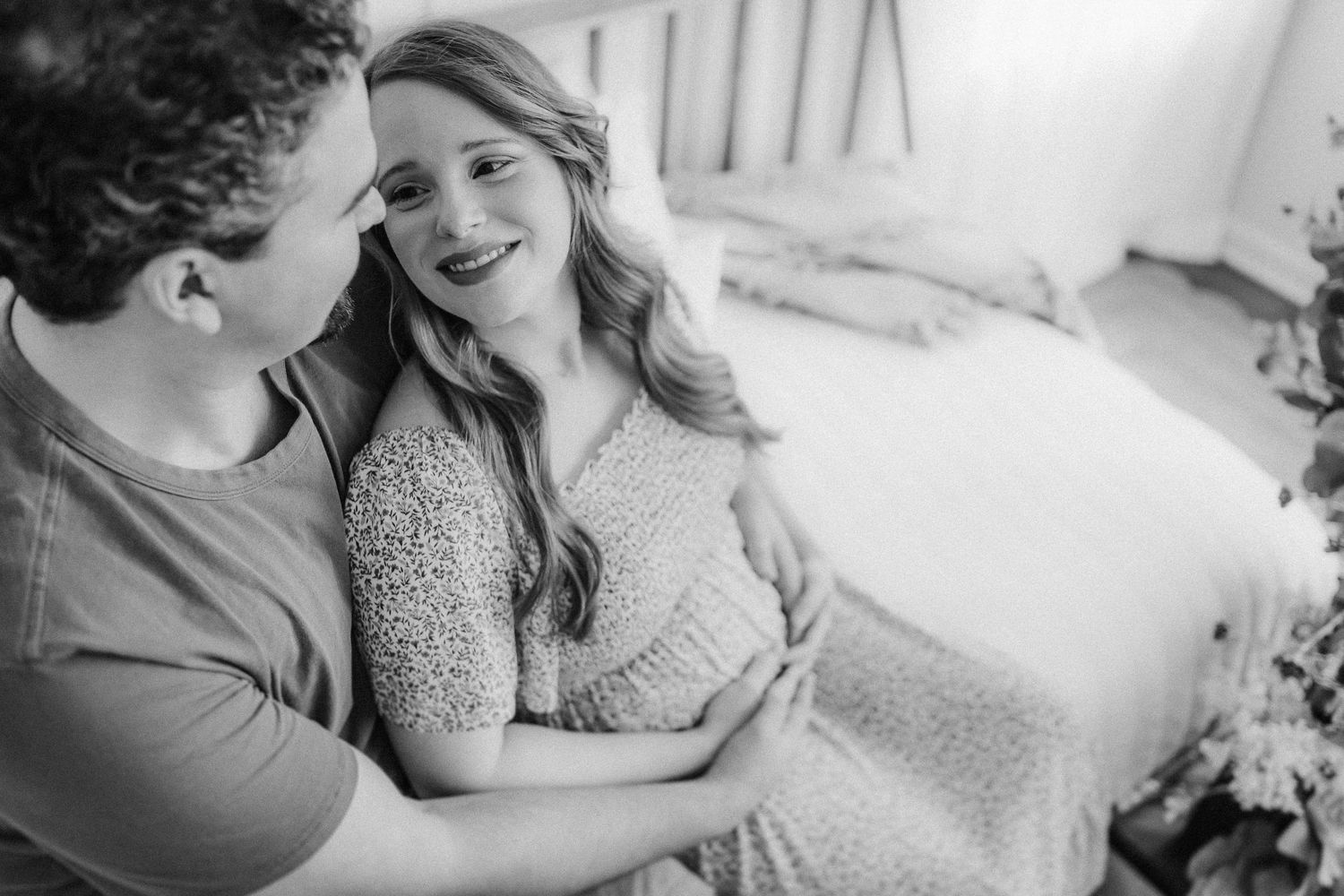 Intimate black and white moment showing a couple sharing laughter together on a porch.