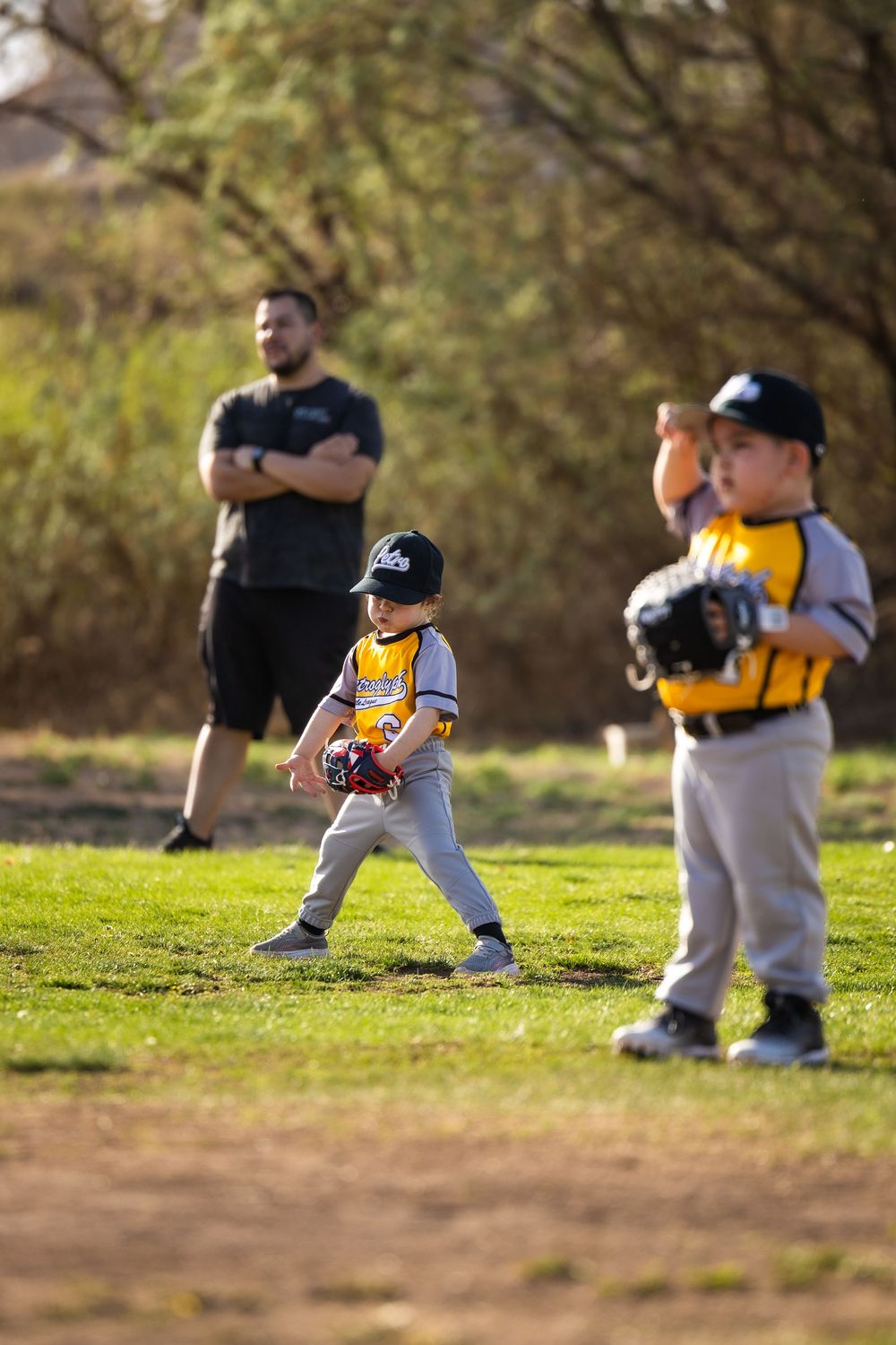 Distracted Little League baseball girl posing on the Albuquerque field. Sports photography by Memorari Portrait in Albuquerque, New Mexico