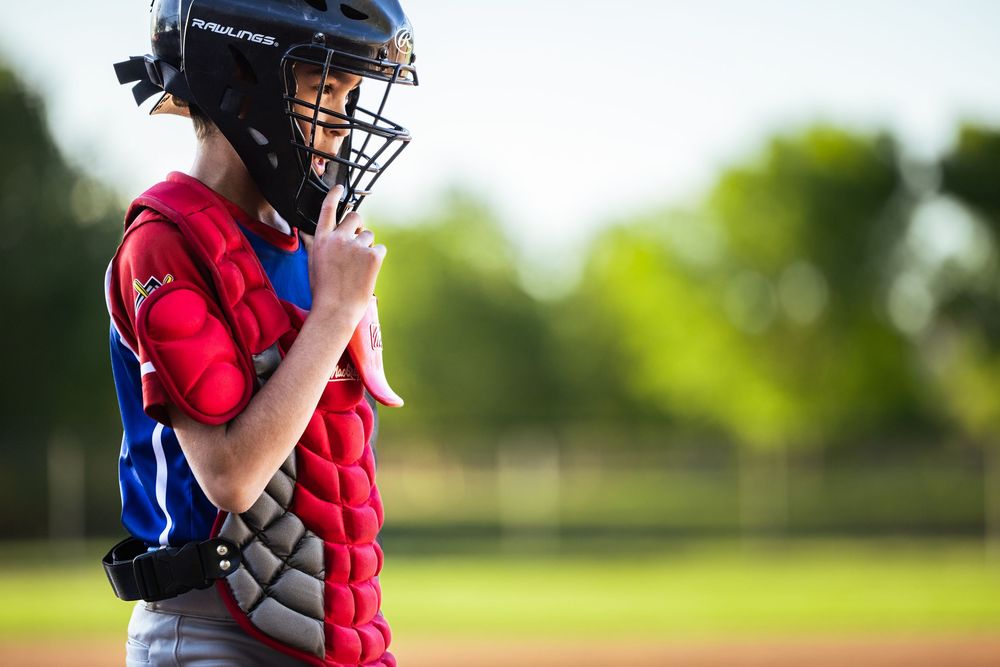 New Mexico Little League baseball sports photography, catcher coming back towards the dugout, adjusting his helmet