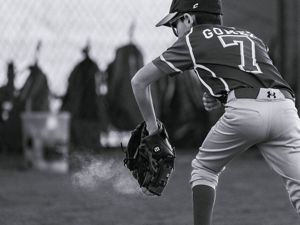 Sports Photography in black and white for New Mexico Little League, Petroglyph, with dust coming from the glove after a catch