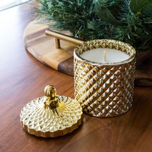 Gold decorative candle holder with geometric pattern and matching lid.