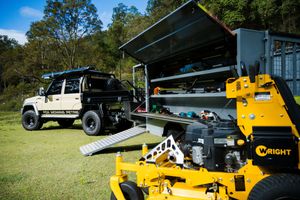 Work truck and transport trailer loaded with commercial lawn maintenance equipment.