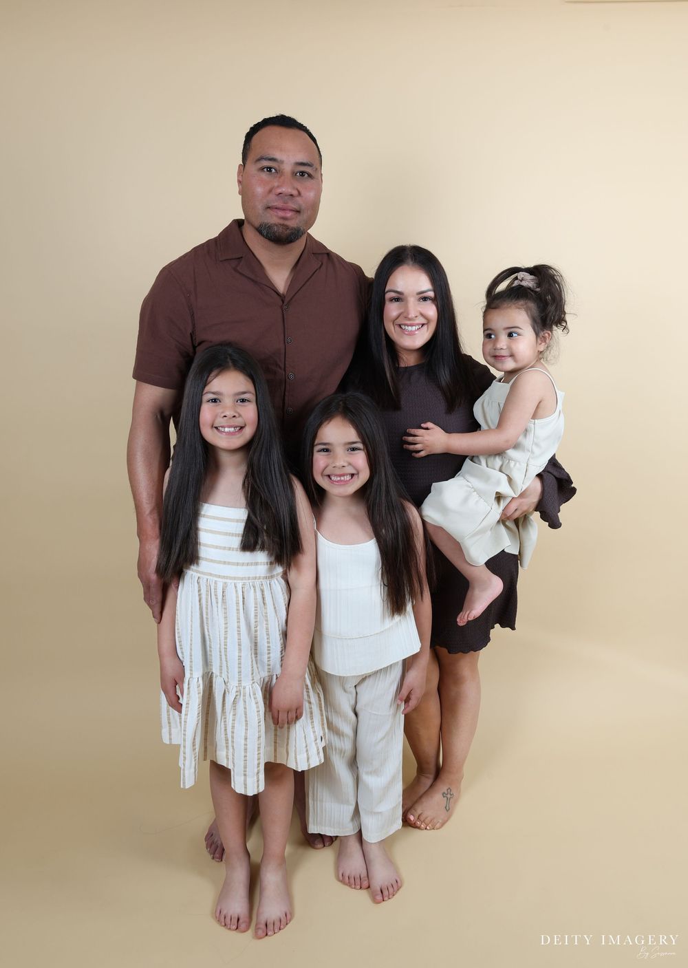 A progression of casual family portraits with people wearing coordinated white and black outfits against a neutral wall.