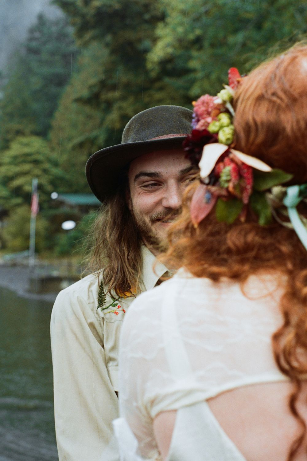Romantic lakeside moment captured between two people in vintage-inspired attire.