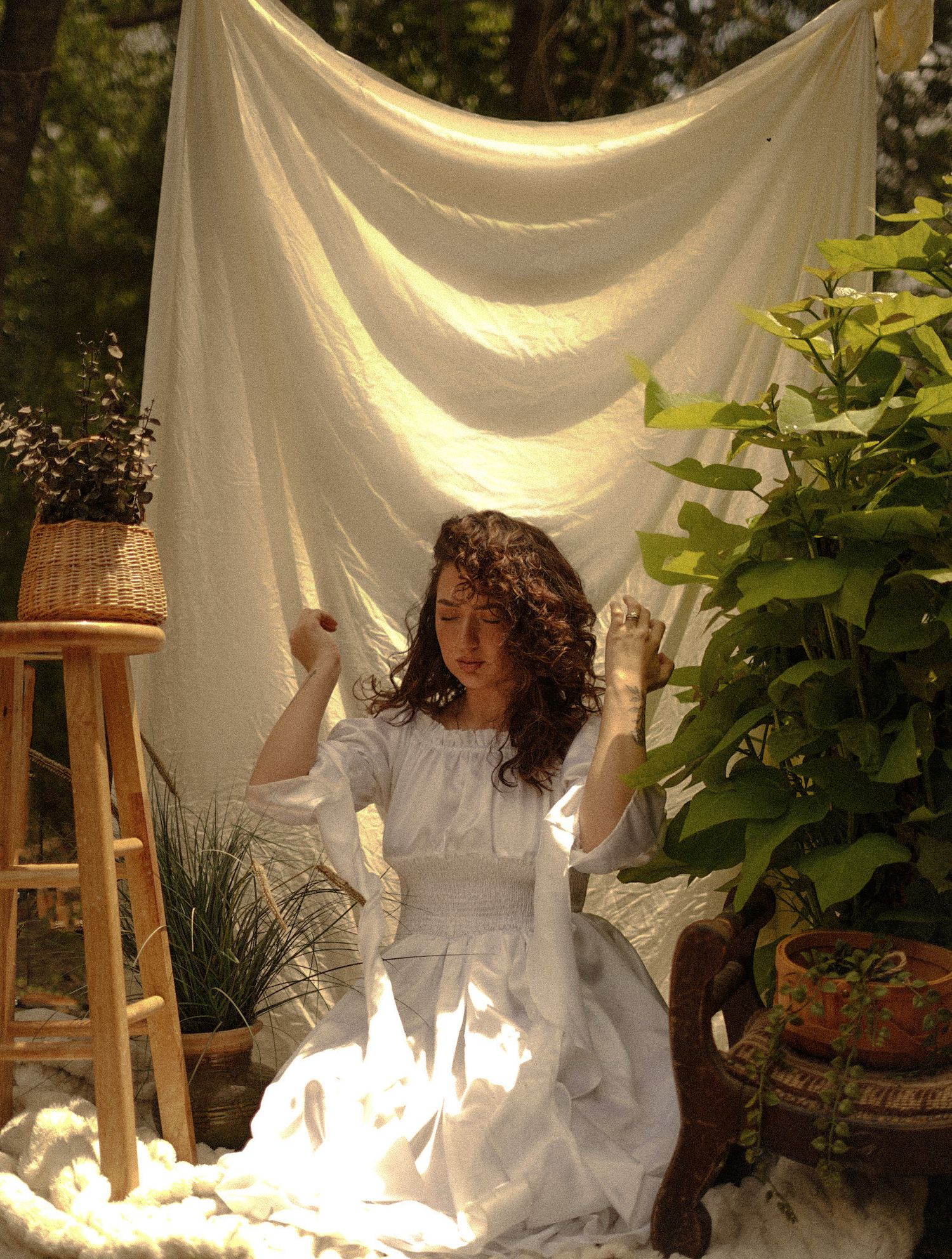 creative photography session. with a model posed in a eclectic, moody, flashy, elegant scene. with greenery and props