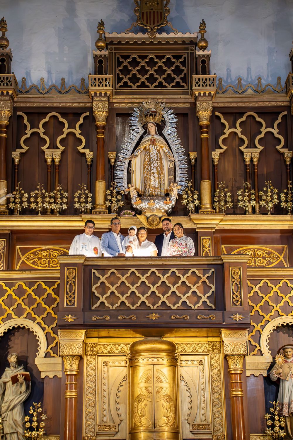 Ornate church altar with gothic architecture and religious imagery in gold and brown tones.