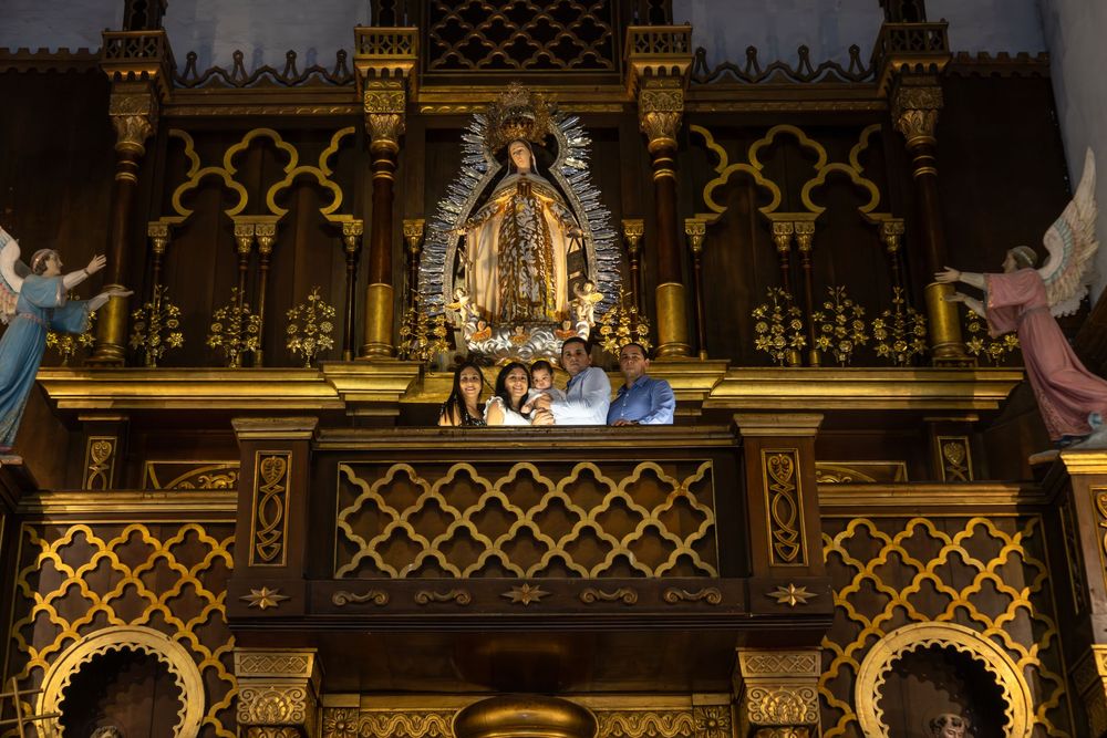 Ornate gold church altar with intricate lattice patterns and religious statues displayed in dramatic lighting.