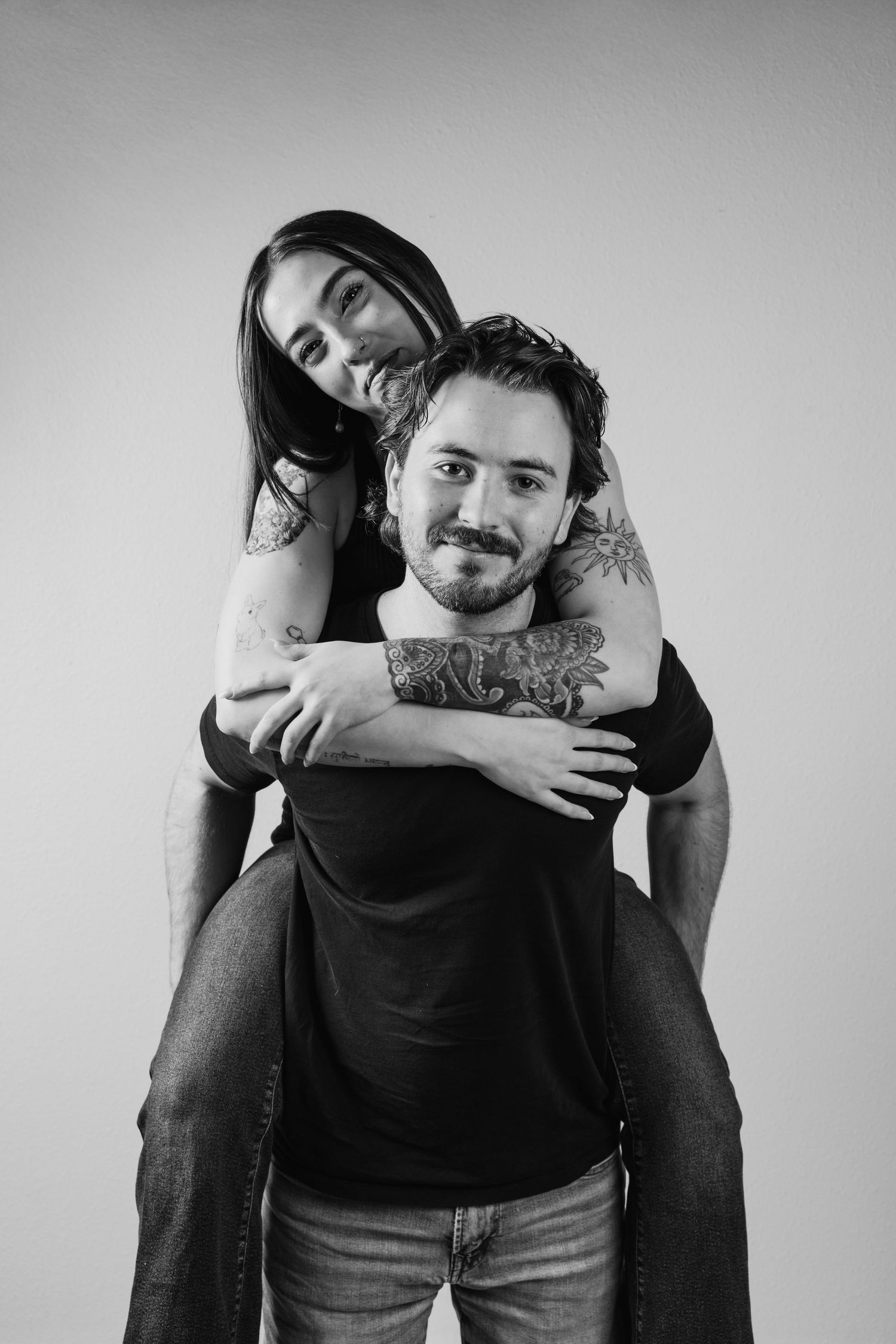 Monochrome series capturing tender moments between a couple in black shirts and jeans.