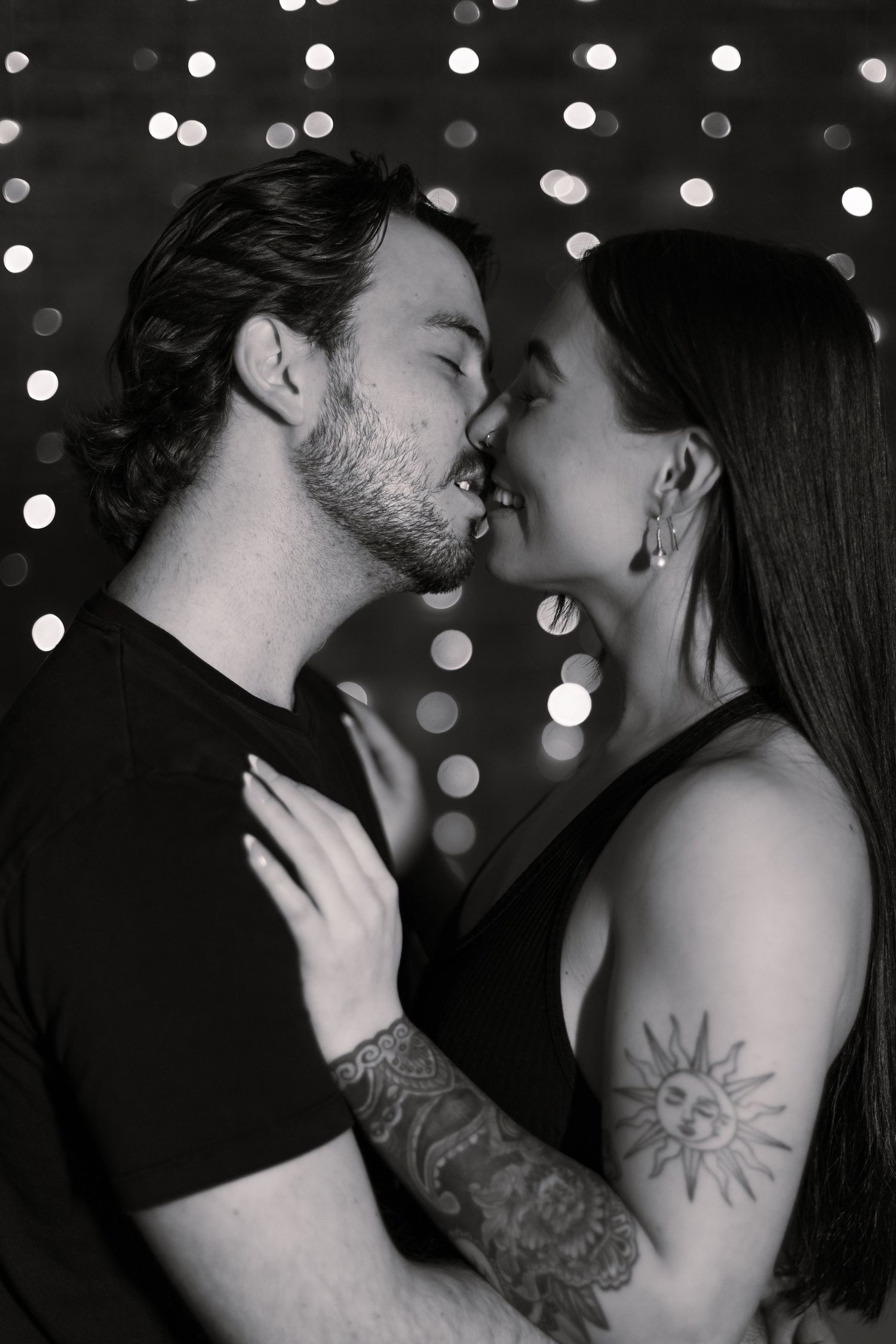 Romantic black and white photo series showing intimate couple moments with bokeh lights in background.