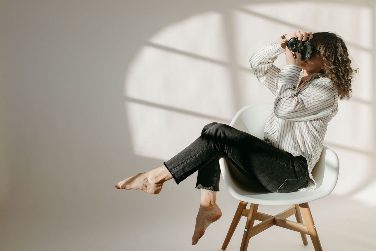 event and brand photographer in Stockholm sitting in a chair in a studio while looking into her camera