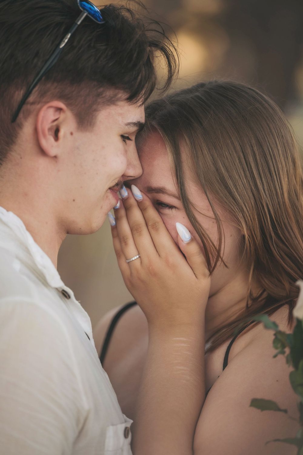 An intimate close-up of a couple sharing a tender moment outdoors.