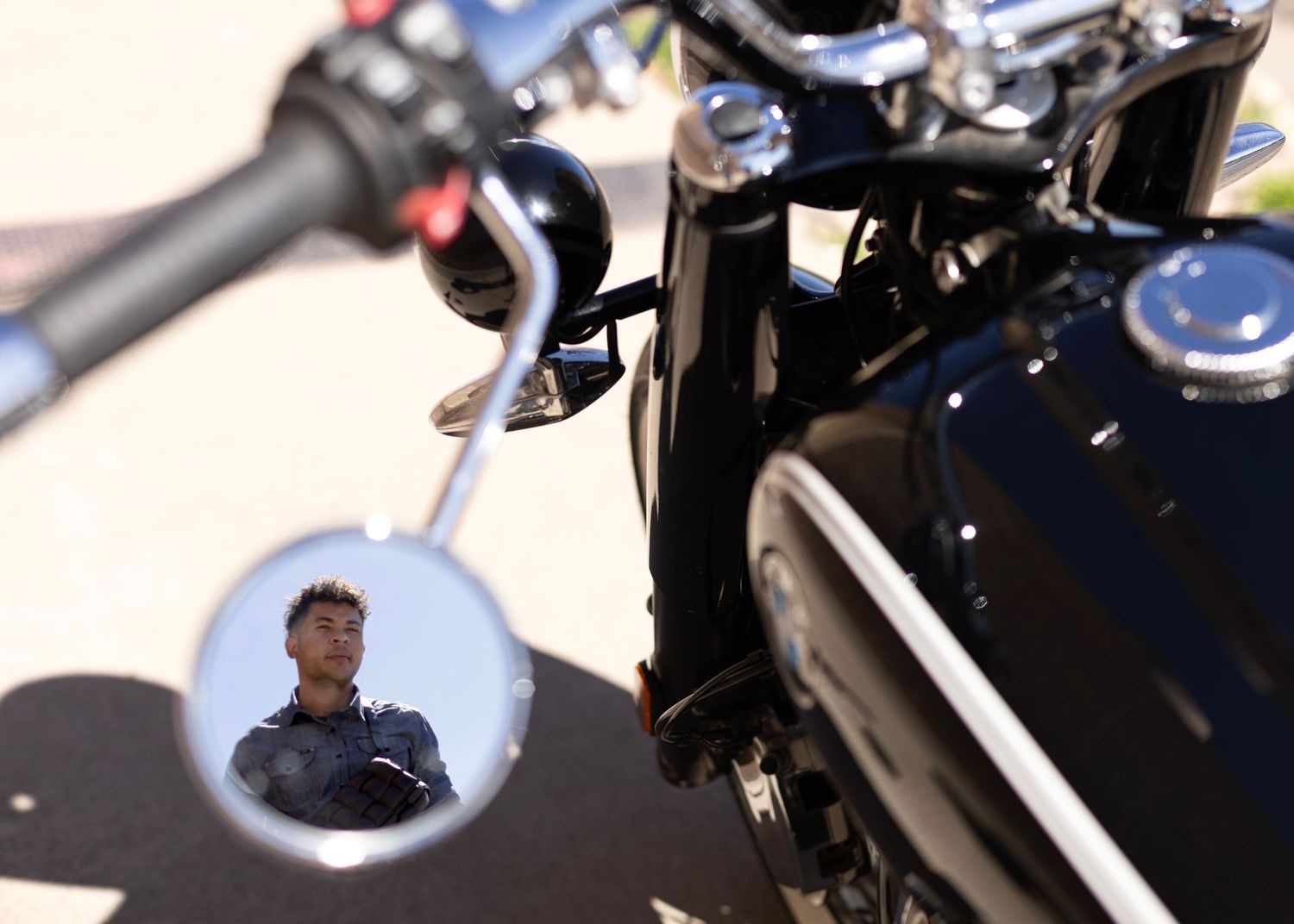 Close-up view of a motorcycle mirror reflection and handlebars.