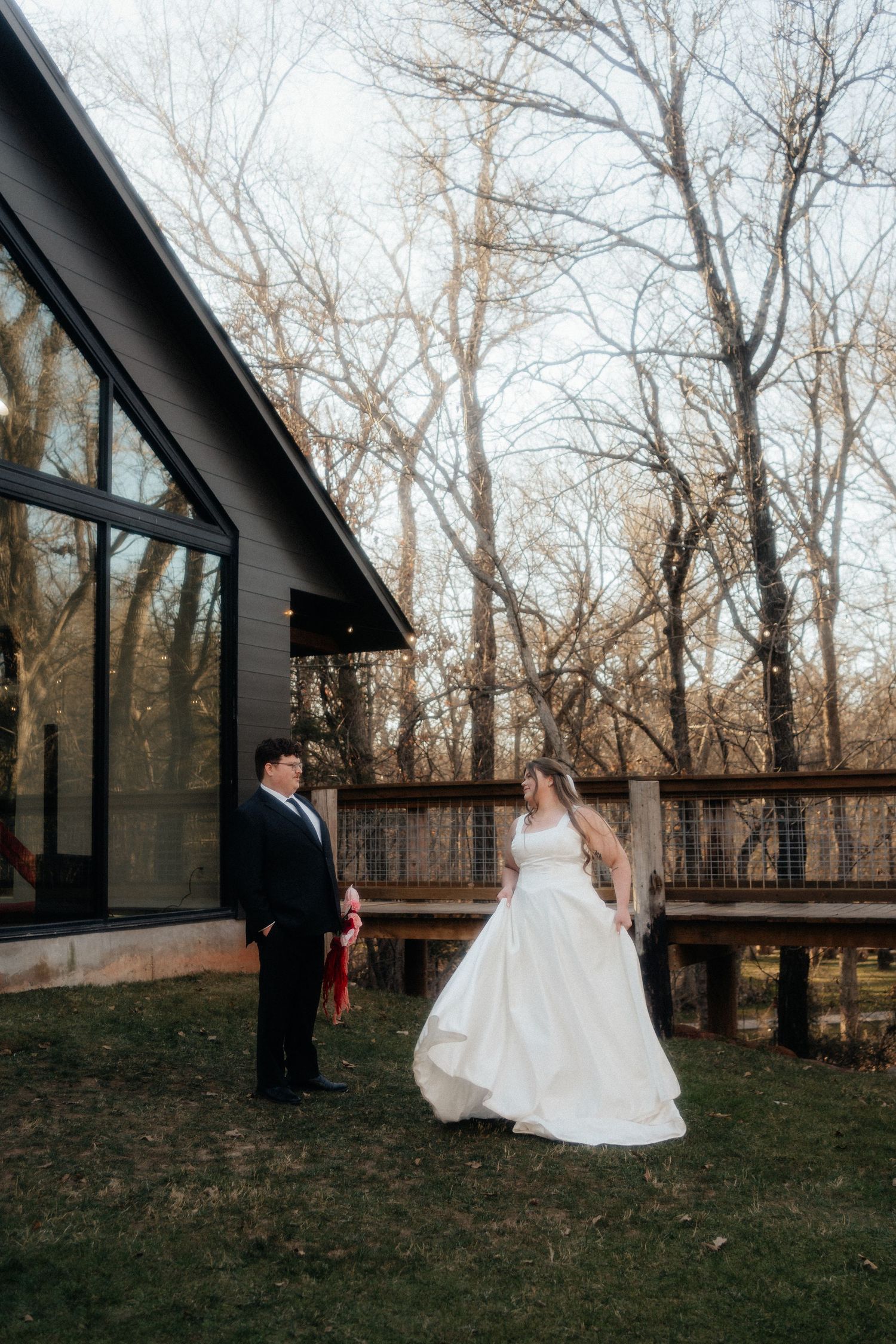 Couple walks hand in hand through winter landscape in wedding attire.