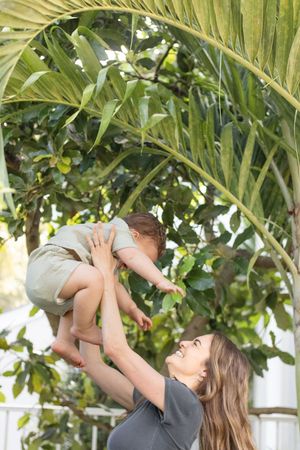 mother lifting up baby boy