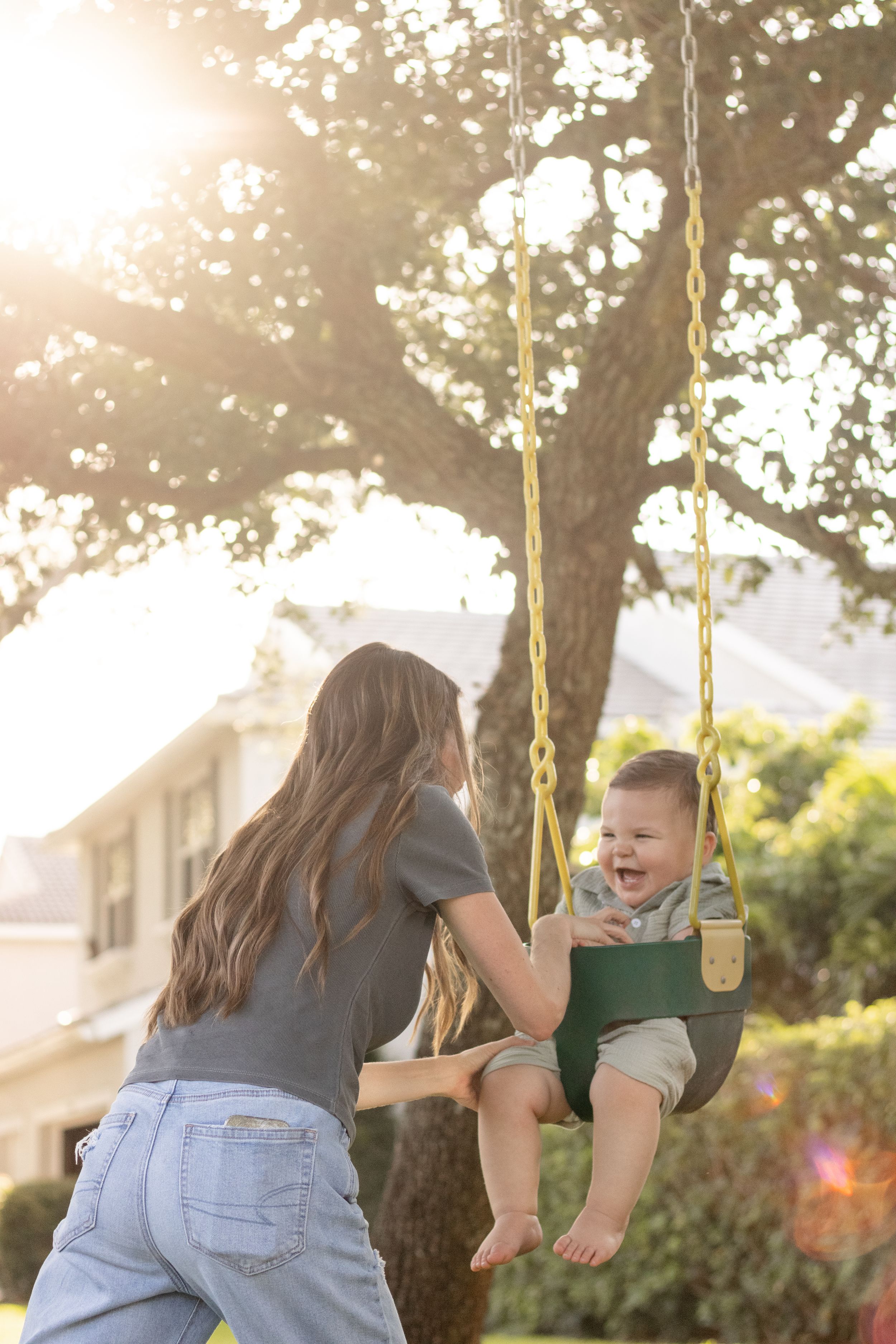 mother swinging son on swing