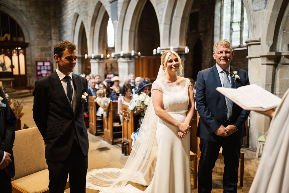 A bride and groom share a joyful moment during their church wedding ceremony.