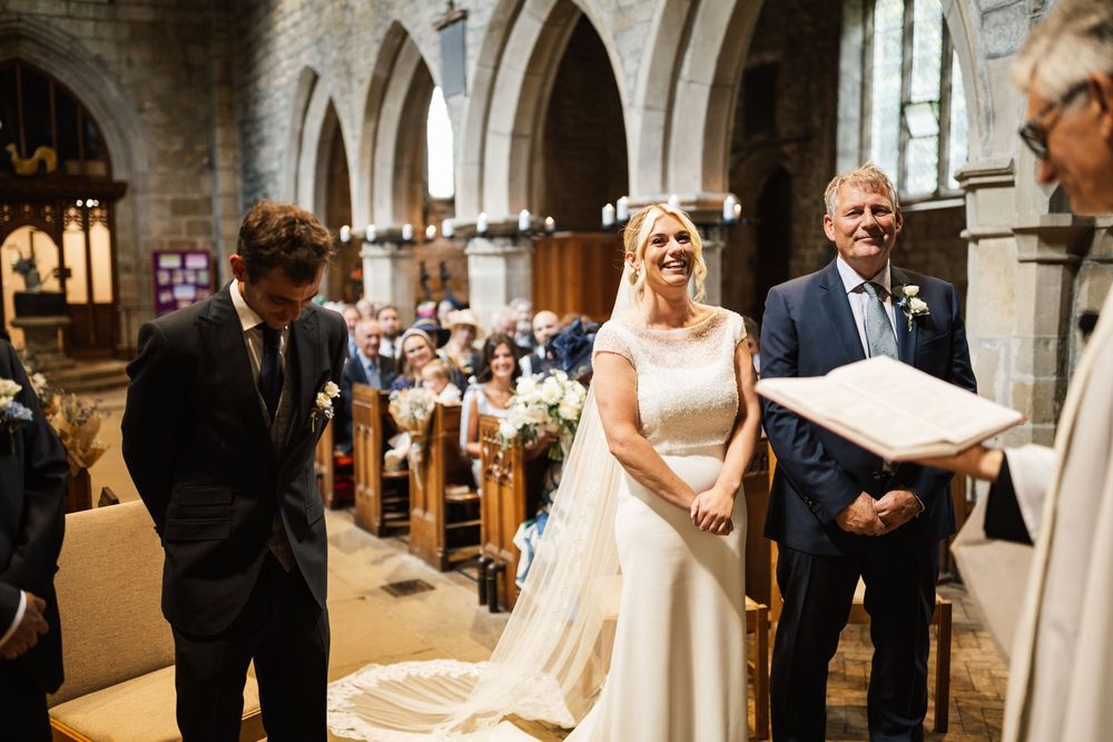 Traditional church wedding ceremony taking place in a historic stone cathedral with vaulted ceilings and archways.