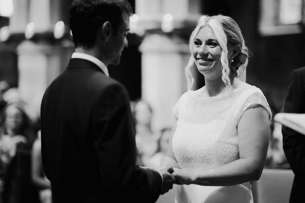 A couple shares a joyful moment during their wedding celebration in black and white.
