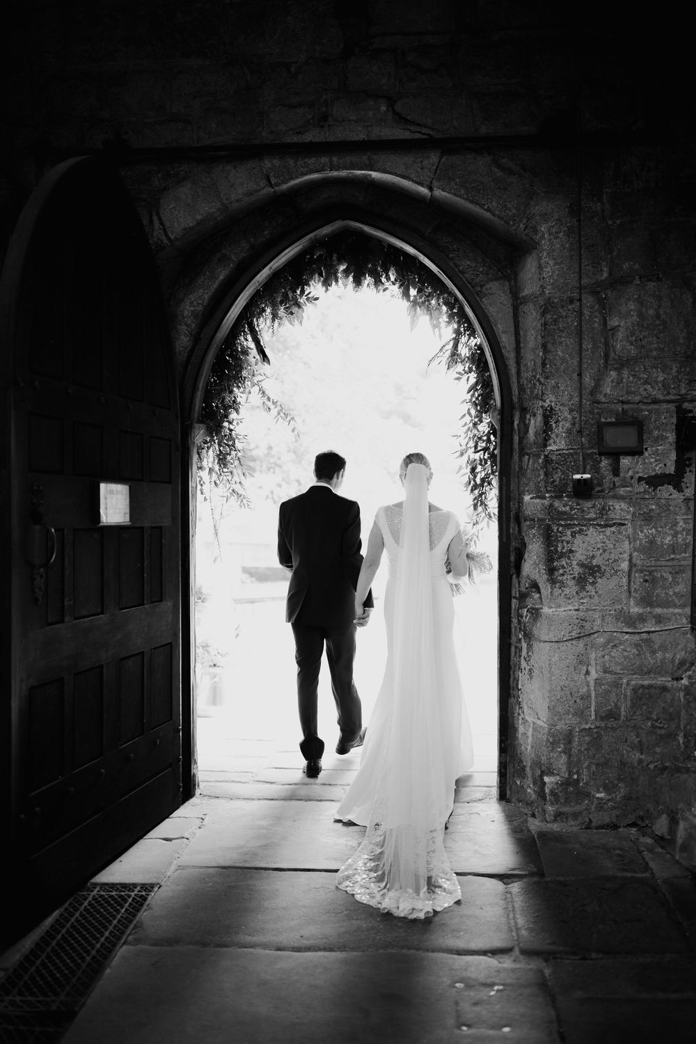 A black and white photo sequence showing a couple walking through a tunnel towards bright daylight.