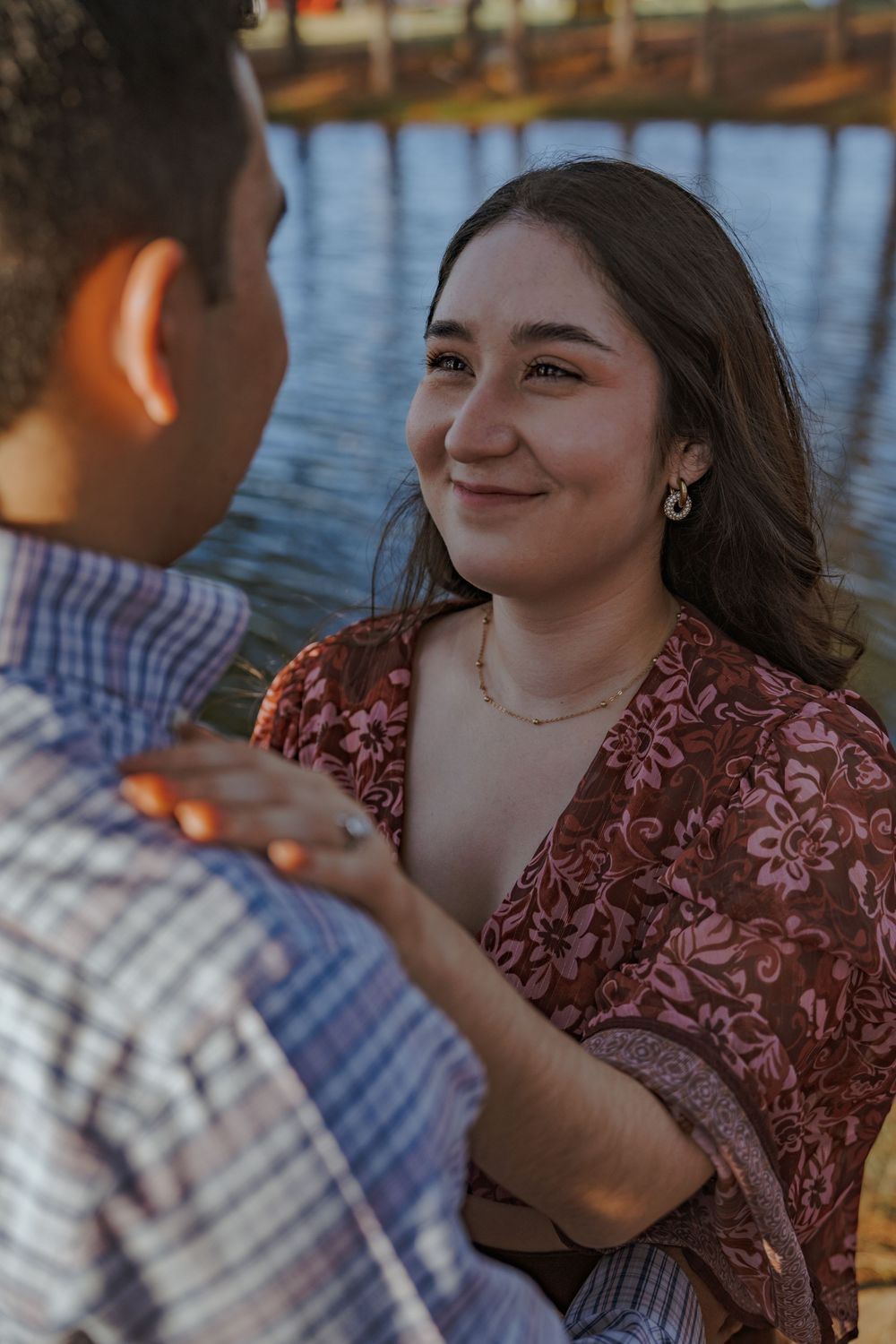 A couple shares joyful moments together on a wooden dock by the water.