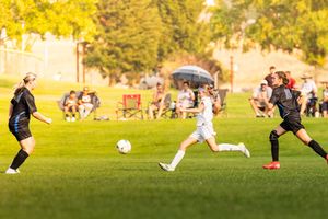 Soccer match action sequence showing players in motion during sunset game.
