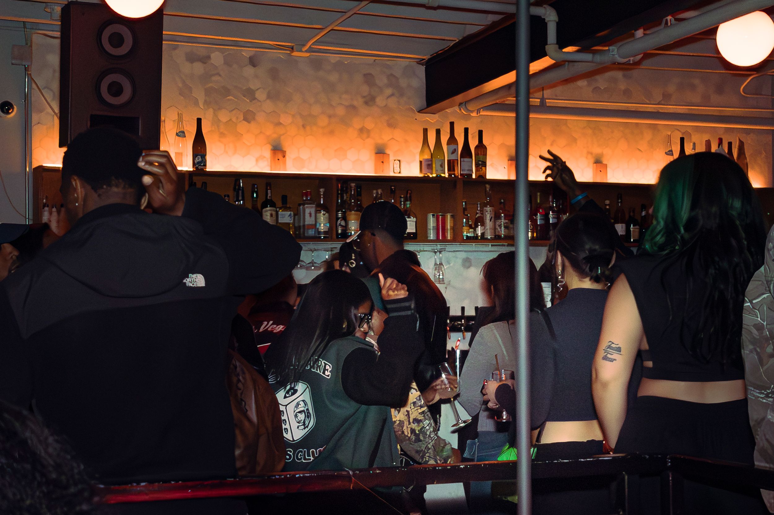 Dimly lit bar or club interior with ambient orange lighting.
