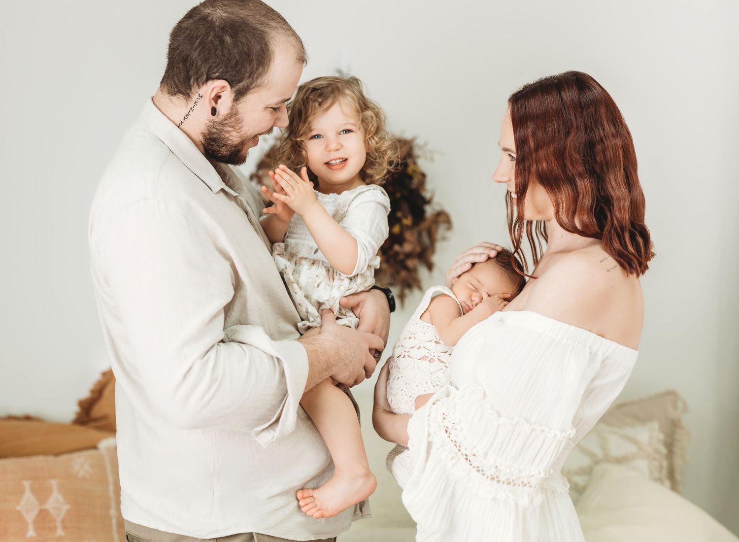 Family sharing intimate moments together in white studio setting.