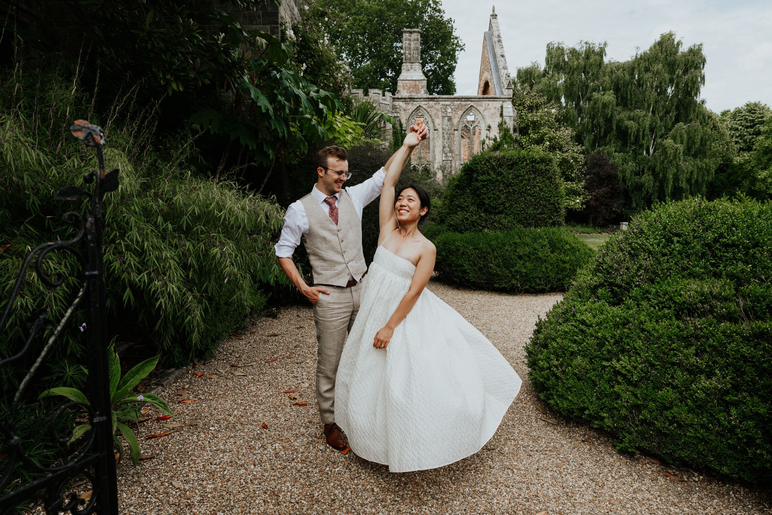 Bride and groom walking together through gardens at Nymans Gardens wedding