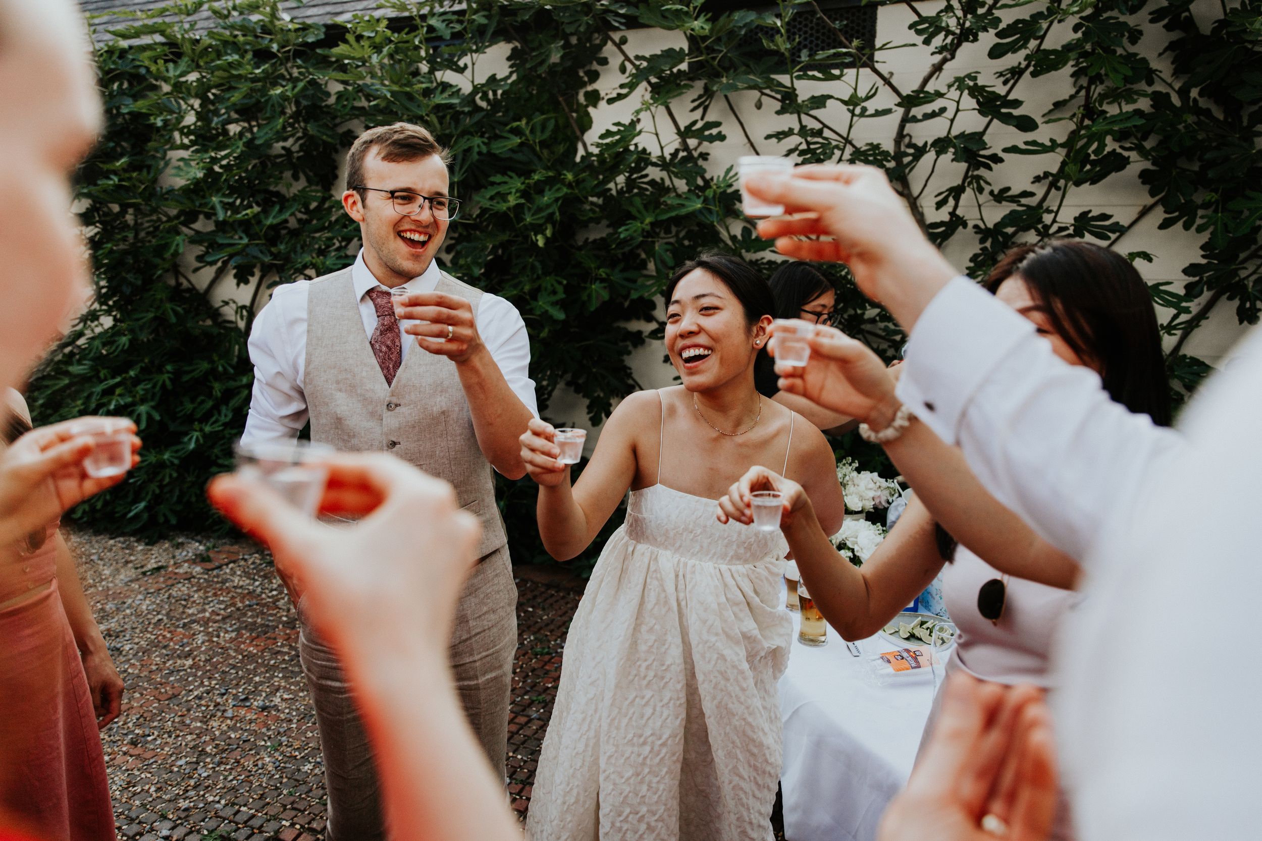 Bride and groom celebrating with guests at Nymans Gardens wedding