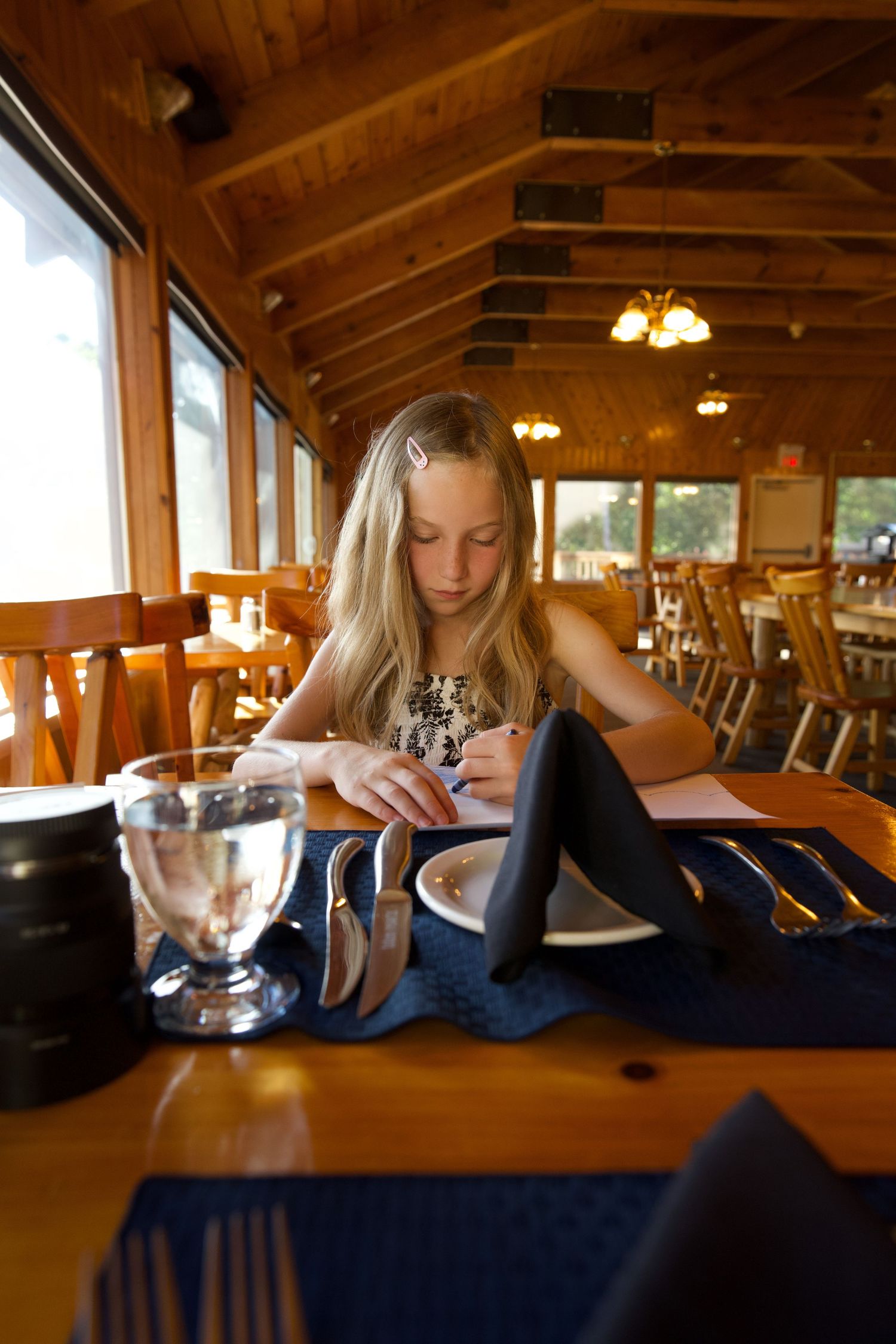 Restaurant interior with wooden beams and warm lighting during dining service.