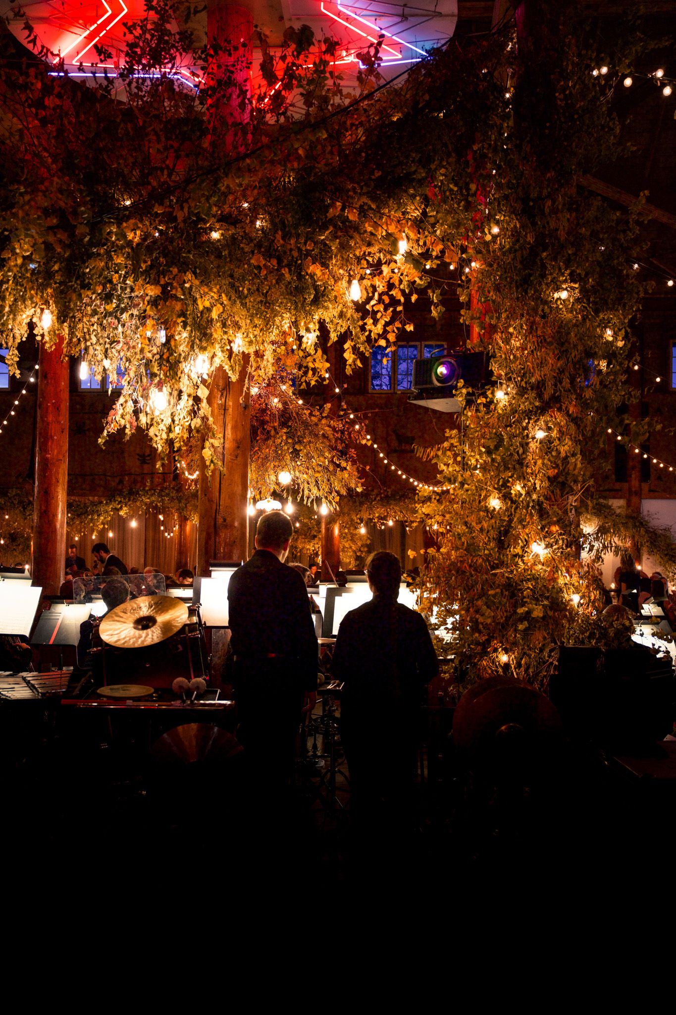Red and amber lighting creates a dramatic atmosphere at an evening outdoor venue.